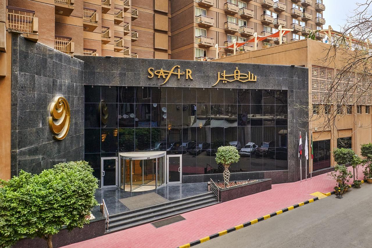 Safir Hotel Cairo Giza Ngoại thất bức ảnh The photo depicts the entrance of a modern building, which appears to be a hotel or a commercial establishment. The facade features a large glass front with reflective surfaces. Above the entrance, there is a prominent sign displaying the name of the